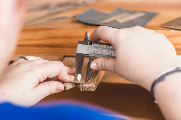 Precision measurement being taken with a caliper for a custom furniture or interior design component