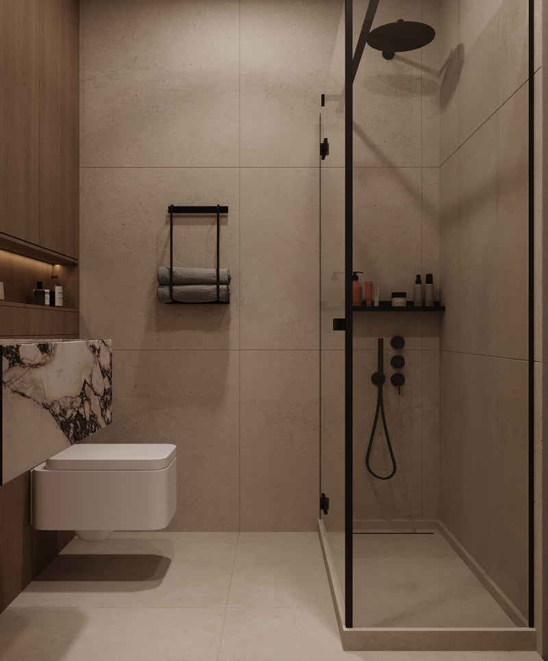 Modern bathroom with beige tiles, a toilet, and shower area.