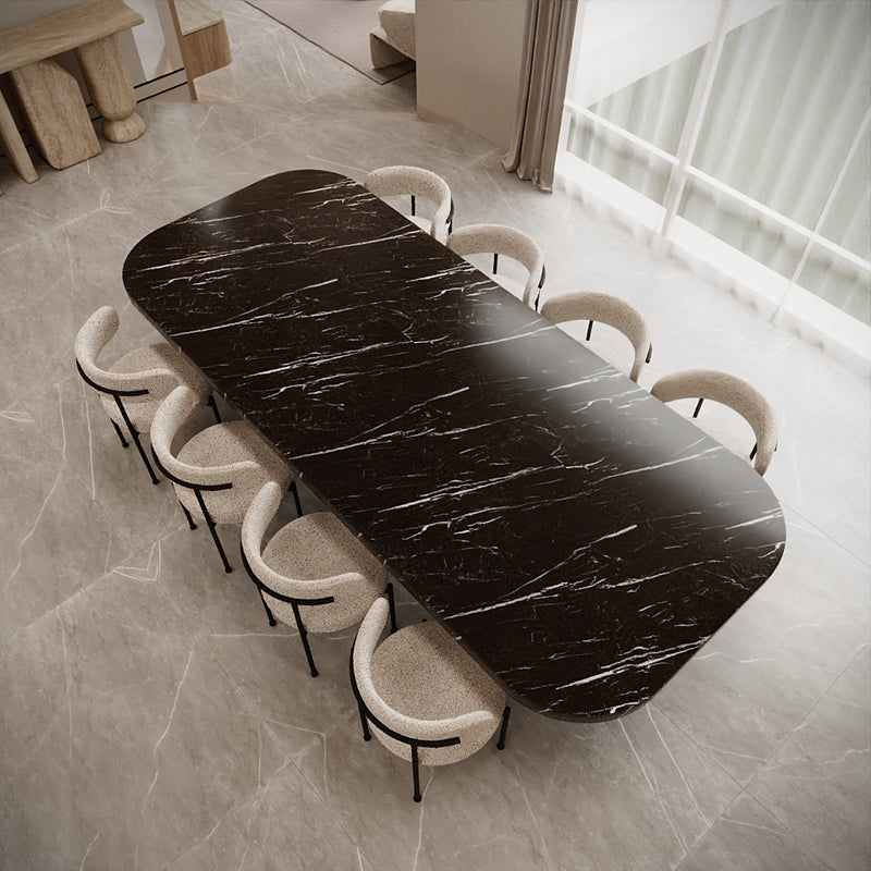 Dining table with marble finish surrounded by chairs in a modern room.