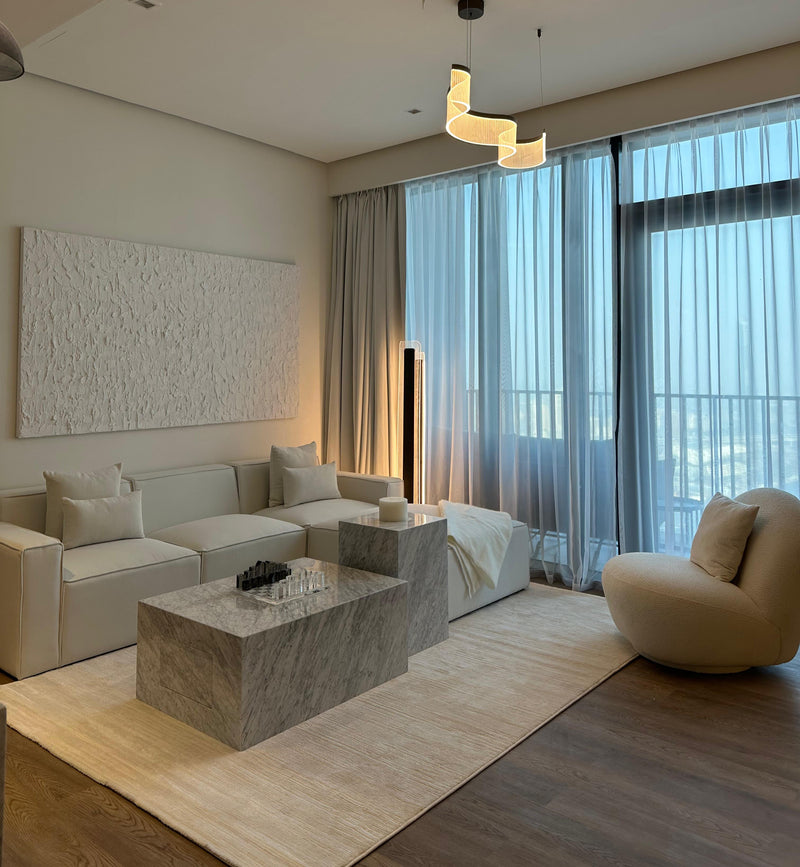 Luxury apartment interior with sheer curtains, a unique spiral chandelier, and a neutral, plush aesthetic