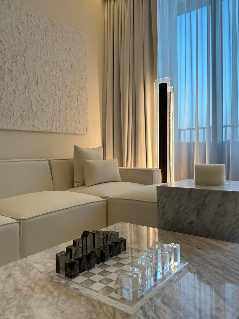 Luxury apartment interior with sheer curtains, a unique spiral chandelier, and a neutral, plush aesthetica