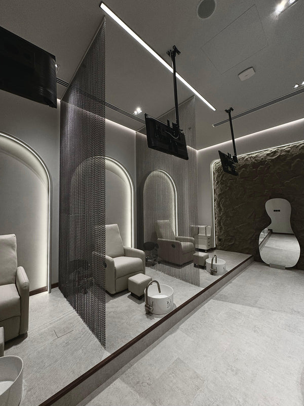 Luxury spa interior design with stone texture wall and minimalist mirror, highlighting the salon's sophisticated and calming design.