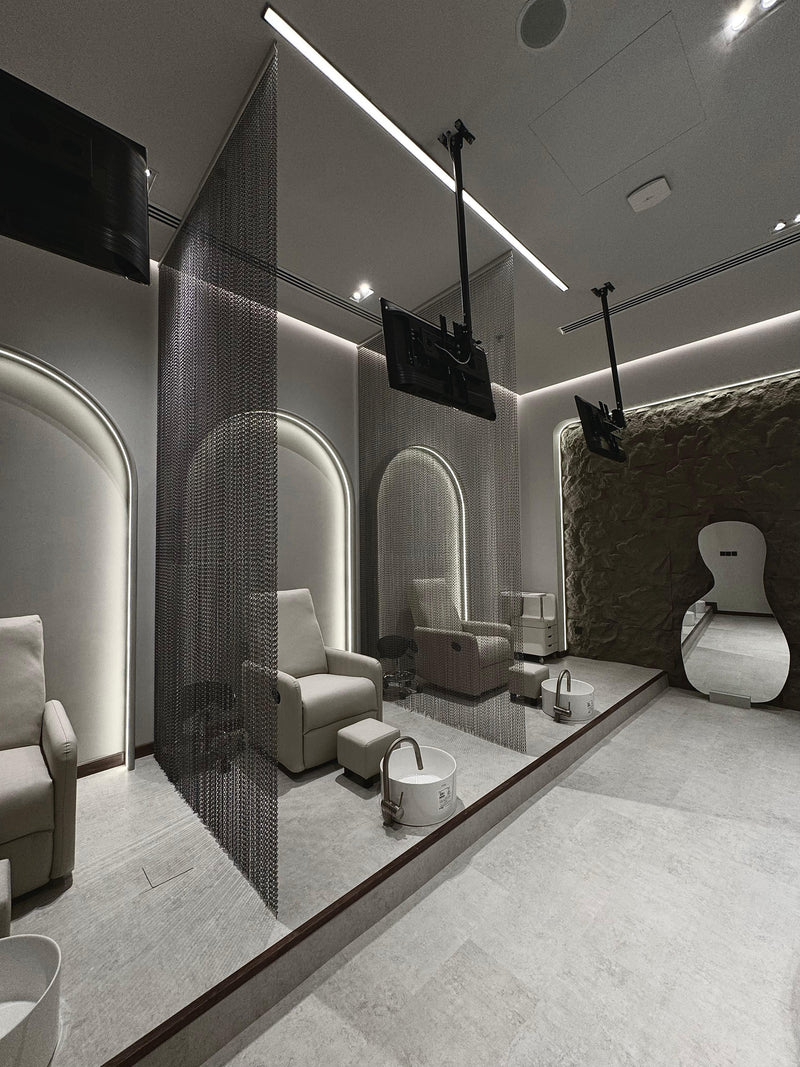 Luxury spa interior design with stone texture wall and minimalist mirror, highlighting the salon's sophisticated and calming design.