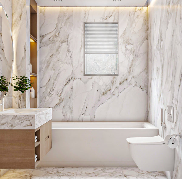 Modern bathroom with marble walls and floor, featuring a bathtub and toilet.
