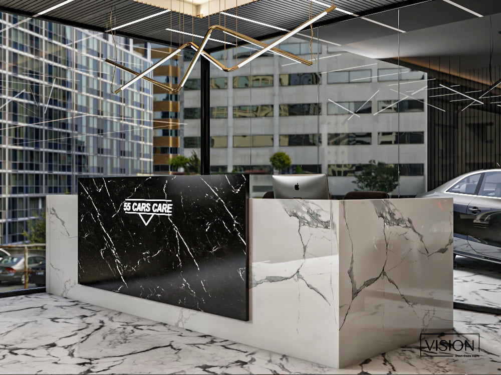Modern car dealership interior with a marble reception desk and digital display.