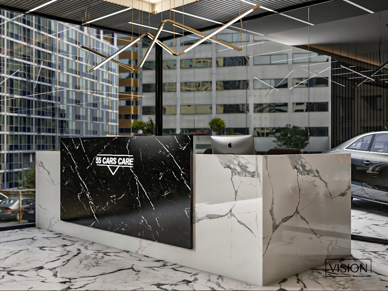 Modern car dealership interior with a marble reception desk and digital display.