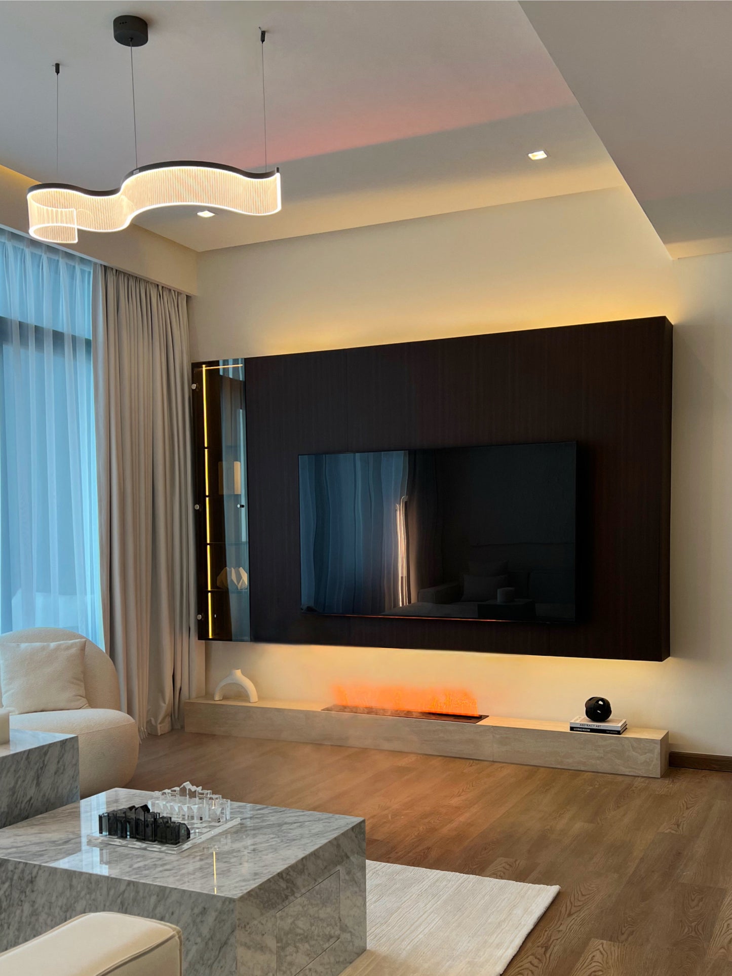 Modern living room with a large flat-screen TV mounted on the wall.