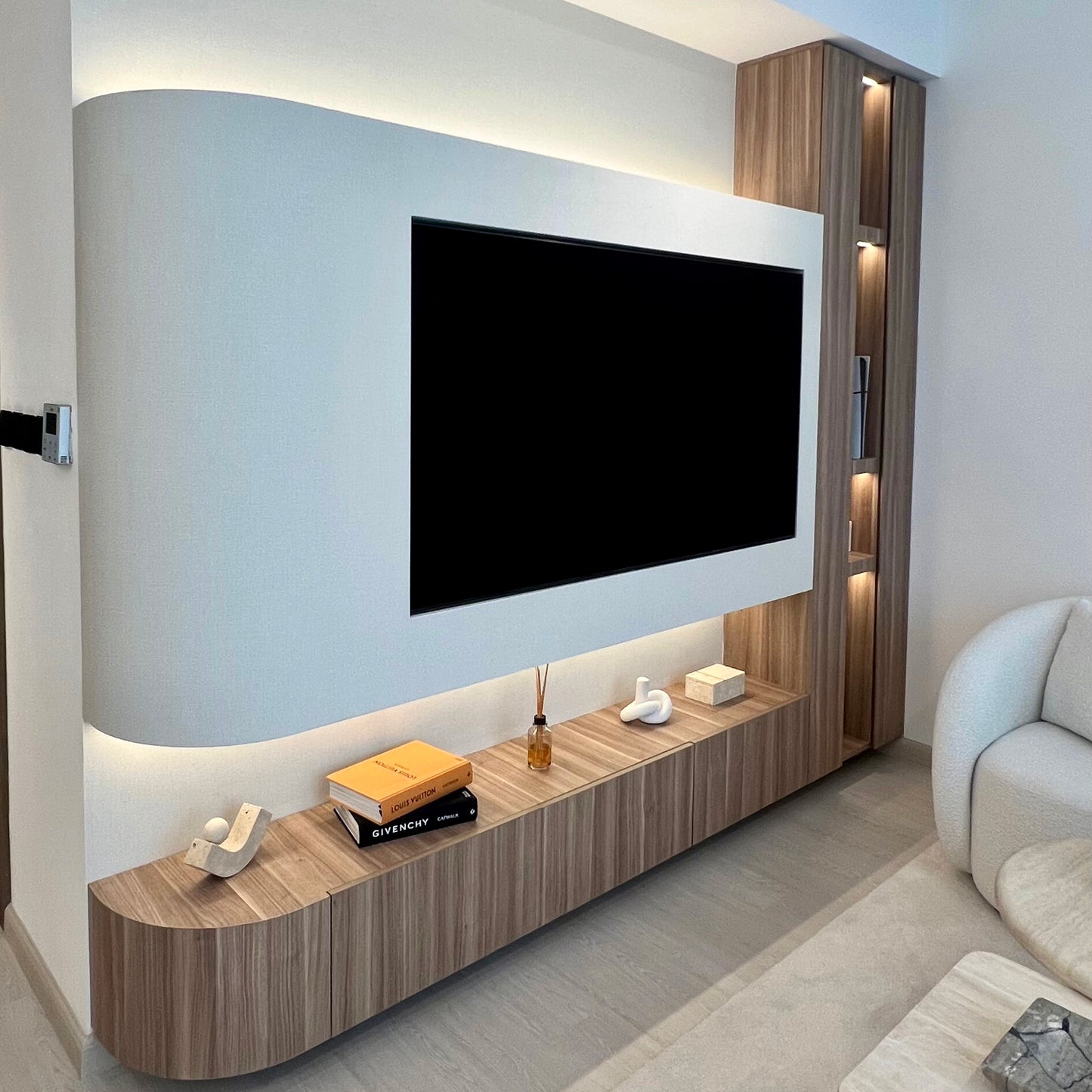 Modern living room with a television mounted on a wall and a wooden entertainment console.