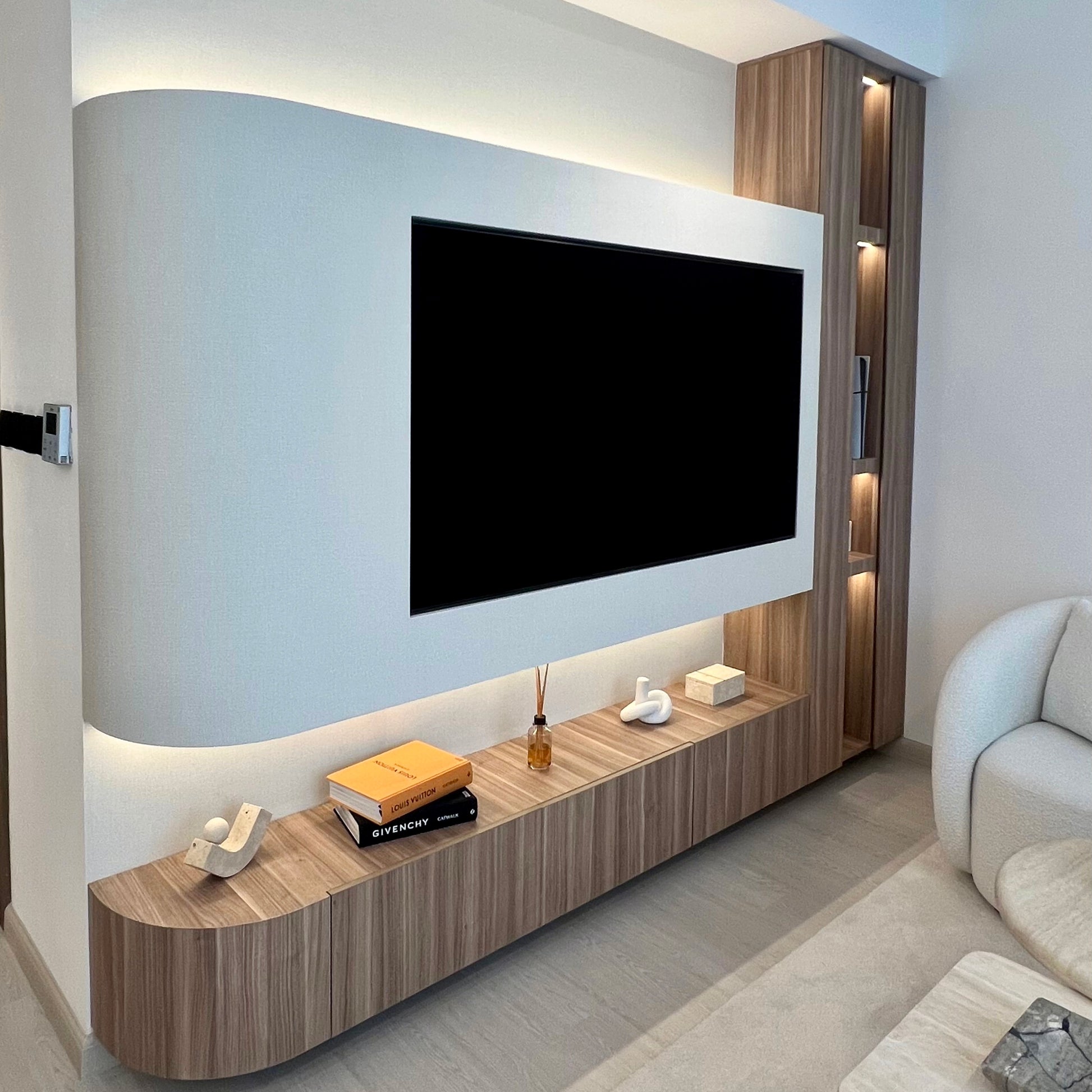 Modern living room with a television mounted on a wall and a wooden entertainment console.