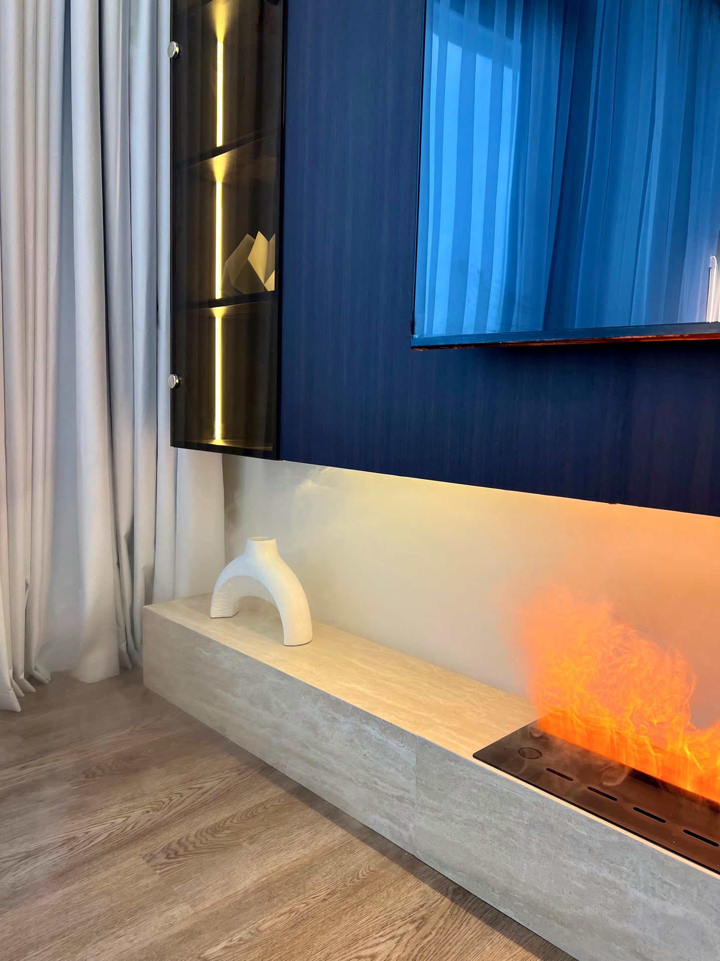 Modern living room with a television mounted on the wall above a fireplace.