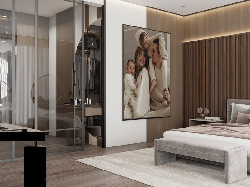 Modern master bedroom with a large mirror, bed, and wall art of a family.