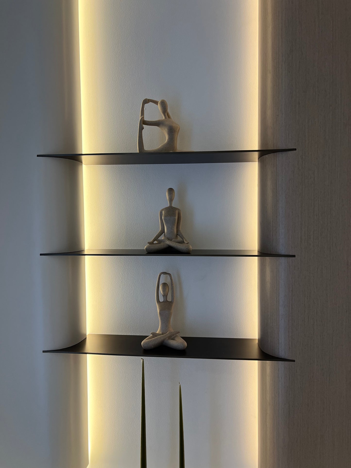 Modern wall-mounted light fixture with three glass panels on a neutral background